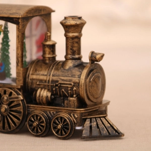 Detail of vintage bronze locomotive decor with internal Christmas tree and warm lighting