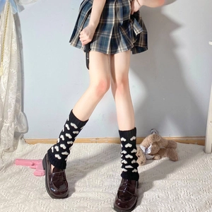 Close-up of black knitted leg warmers with white heart patterns for winter lolita style