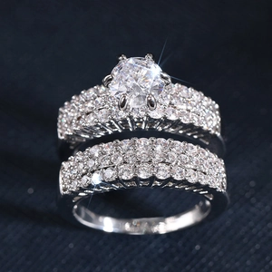 Macro shot of silver wedding ring set with six-prong zircon and pave diamond bands