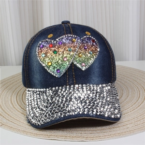 Detail of denim baseball cap featuring rhinestone hearts and silver studded brim decor