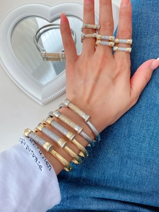 Close-up of sparkling gold and silver horseshoe rings and bangles with pave diamonds