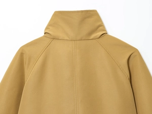 Close-up detail of khaki trench coat collar and shoulder seams with premium twill texture
