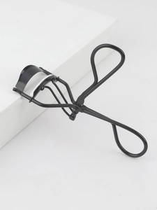 Close-up of black matte stainless steel eyelash curler with white silicone pad