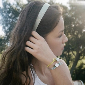 French tortoise acetate headband in beige with floral bracelets on model in outdoor light