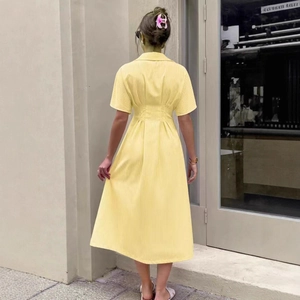 Detail of waist pleats and vertical stripes on back of yellow short-sleeved midi dress