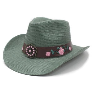 Detail of sage green straw cowboy hat with embroidered floral leather band and bead