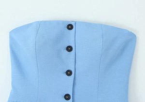 Close-up of sky blue tube top fabric with black buttons and linen texture detail