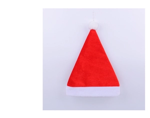 Close-up of a red plush Christmas hat with a thick white faux fur trim and large pompom