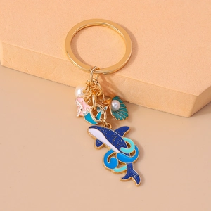 Détail du porte-clés sirène avec baleine bleue et breloque coquillage sur socle
