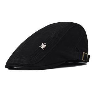 Detail of black cotton duckbill cap showing silver bird logo and adjustable buckle