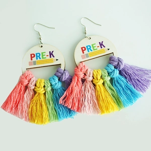 Close-up of rainbow fringe tassel earrings featuring wood PRE-K pencil charms