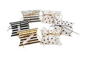 Macro shot of assorted gold silver and black pillow boxes with stripes and dots and tags