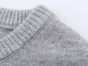 Detailed close-up of the ribbed crewneck and soft wool texture on this gray knit sweater