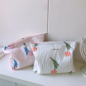 Détails de broderie tulipe sur trousses de maquillage plissées avec étiquettes simples