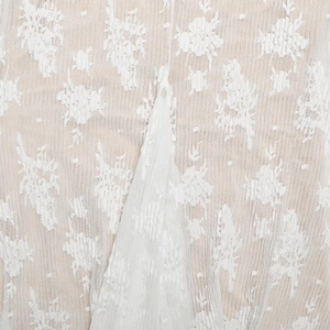 Gros plan sur le tissu en dentelle florale blanche avec broderie 3D et maille texturée