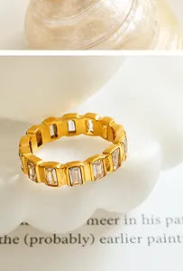 Primer plano de un anillo dorado con cristales de talla baguette en un soporte