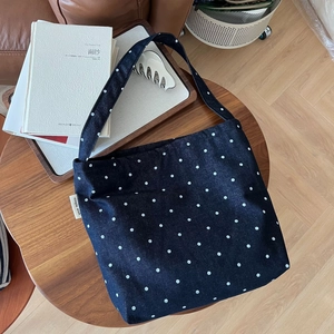 Dark blue denim tote bag with white polka dots and a minimalist shoulder strap design
