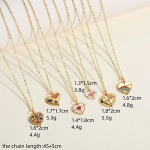 Golden heart pendant necklaces with zircons and enamel details on textured background