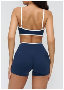 Detail of high-waist yoga shorts with V-shaped stitching and white contrast piping