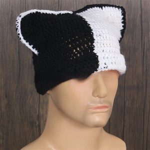 Detail of handmade crochet knit hat with black and white cat ears design for winter