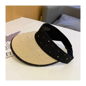 Detailed macro view of beige straw brim with rhinestones and black elastic band on hat