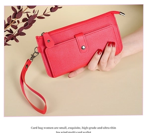 Detail of red long wallet with wrist strap and multiple card slots held in hand