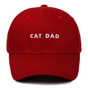 Close-up of white CAT DAD embroidery on a red cotton twill six-panel baseball cap