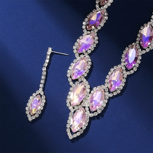 Detailed macro view of silver necklace and earrings set with purple marquise crystals