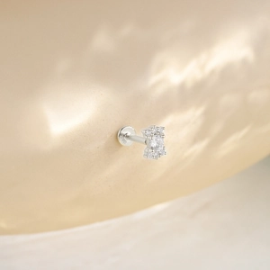 Close-up of S925 hallmark on silver curved cartilage stud with sparkling zircon stones