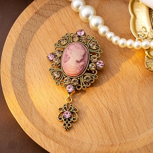 Macro detail of vintage cameo brooch with pink portrait relief and sparkling crystals