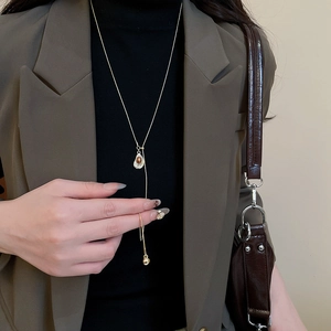 Detail showing vintage gold chain necklace with tiger eye stone heart pendant and fringe