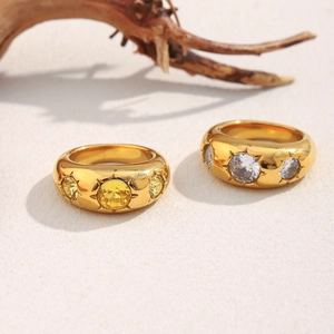 Macro detail of 18K gold plated wide rings with starburst set cubic zirconia stones