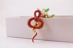 Close-up of a luxury gold snake keychain featuring sparkling red rhinestones and lobster clasp