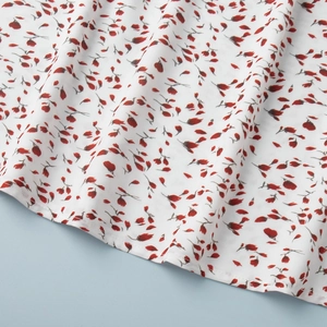 Gros plan détaillé du tissu floral montrant des fleurs rouges sur une robe d'été