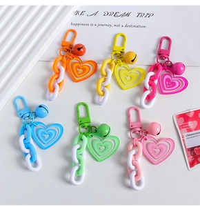 Detailed close-up of six colorful heart-shaped keychains with bells and acrylic charms