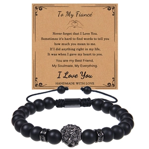 Detail of matte black stone bead bracelet with metal lion head charm and gift message card
