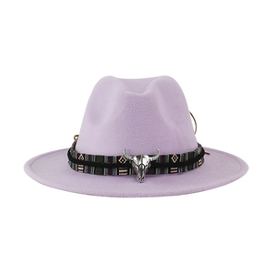 Dettaglio del cappello fedora lilla con testa di toro argentata e fascia etnica.