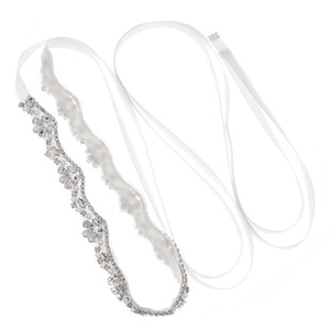 Macro detail of bridal belt featuring intricate crystal rhinestones and pearls on white ribbon