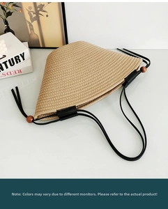 Detail of a foldable khaki straw hat showing portable design and black lanyards