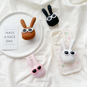 Plush bunny phone grip with cool sunglasses on a clear star case and white fabric