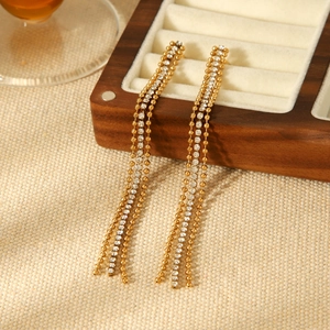 Boucles d'oreilles pampilles en acier doré et zircons sur tissu beige doux