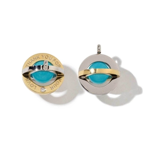 Detail of ball pendant with blue stone, two-tone gold and silver finish and engraving