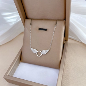 Detail of silver angel wing necklace with sparkling rhinestones in a gold jewelry box