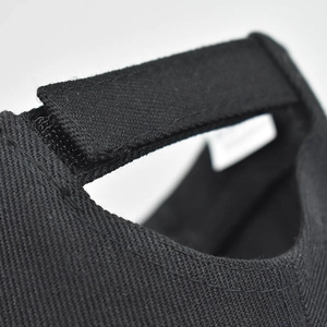 Close-up of the adjustable velcro strap on the back of a black twill cotton baseball cap