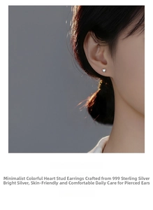 Close-up of S999 sterling silver heart stud earrings with iridescent cubic zirconia