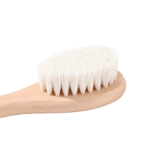 Natural wooden baby hairbrush with soft white wool bristles for gentle scalp massage