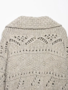 Detail of chunky knit hollow-out pattern on the back of a beige oversized cardigan