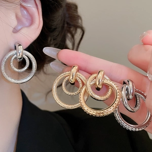 Vue détaillée des boucles d'oreilles doubles cercles entrelacés en or et argent