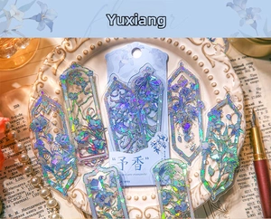 Close-up of laser PET stickers with blue floral patterns and gold foil on vintage books