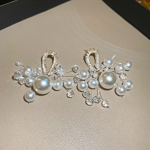 Detailed macro view of French style cluster earrings with pearls and zircon tassels